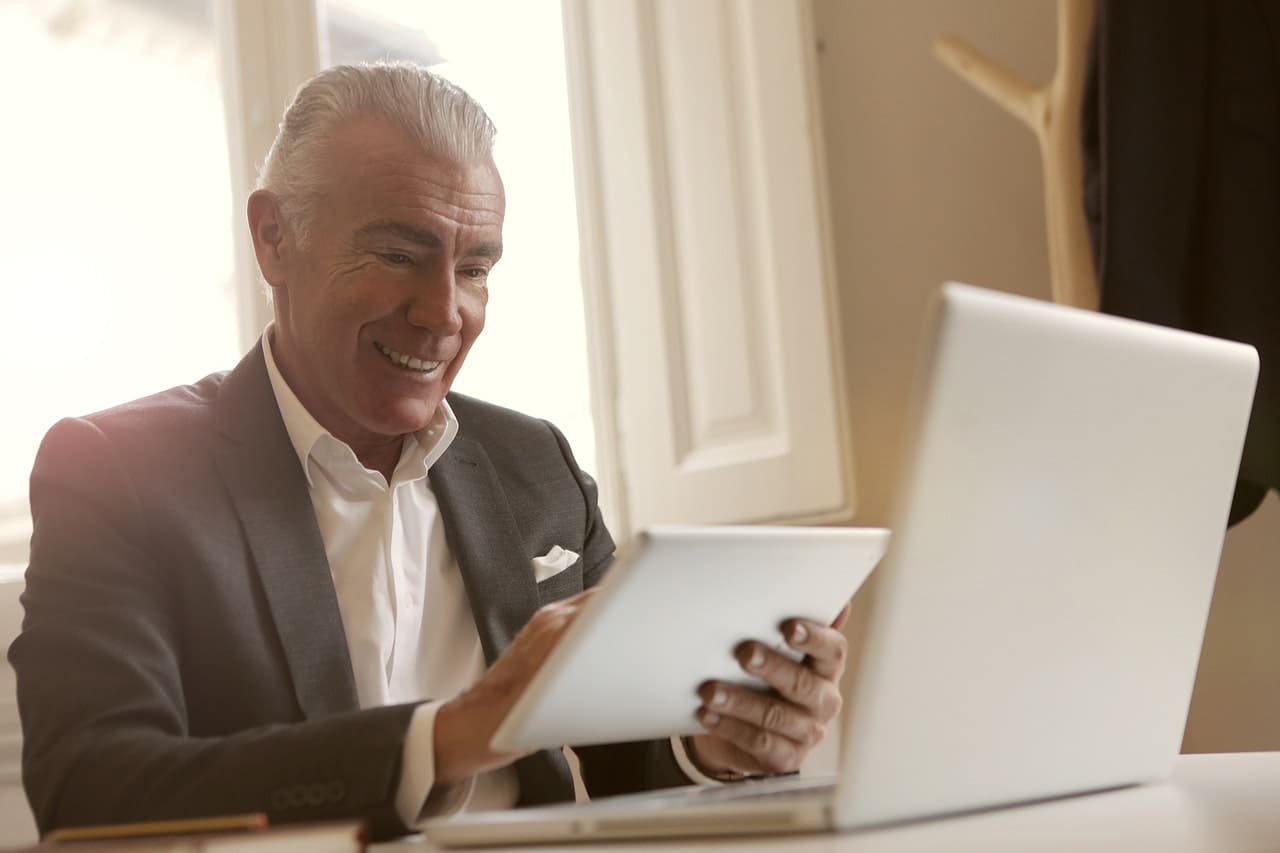 senior man on a computer saving money on a funeral